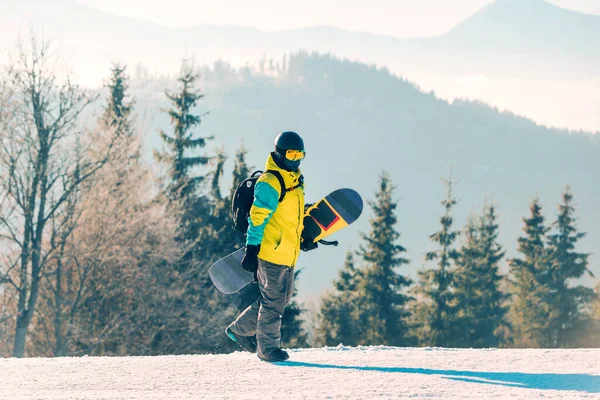 Arka Planda Snowboard Dağlarıyla Tepenin Yanından Geçen Bir Adam — Stok fotoğraf