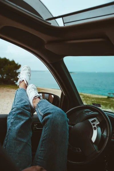 woman resting in car parked at sea beach. summer vacation