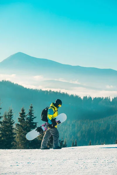 Arka Planda Snowboard Dağlarıyla Tepenin Yanından Geçen Bir Adam — Stok fotoğraf