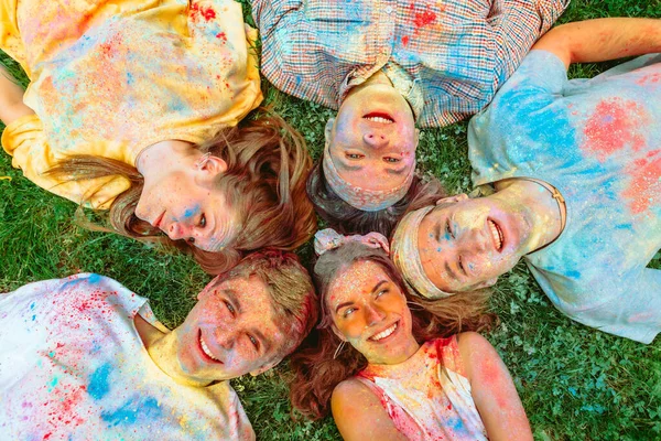 Amigos Felizes Deitado Chão Grama Verde Sujo Tintas Holi Feriado — Fotografia de Stock