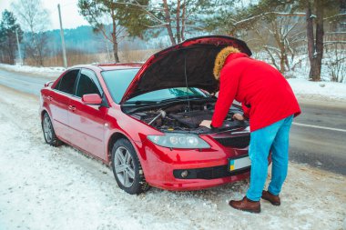 Adam arabanın kaputunu açtı. Karayolunda arıza var. Sigorta yardımı. Boşluğu kopyala