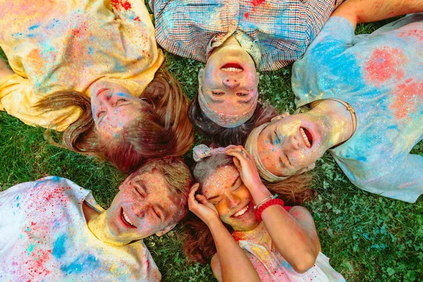 Amigos Felizes Deitado Chão Grama Verde Sujo Tintas Holi Feriado — Fotografia de Stock