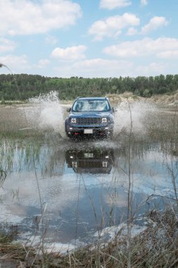 off road konsepti. Araba bataklık bariyerini aşıyor. Boşluğu kopyala