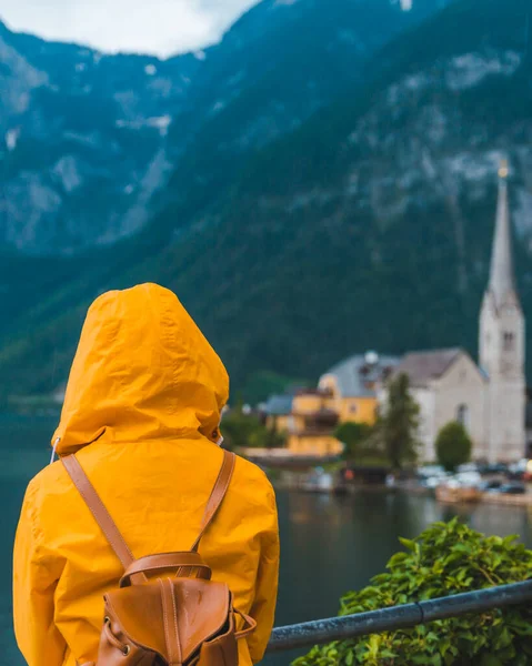 Sarı Yağmurluklu Kadın Hallstatt City Panoramik Manzarasına Bakıyor — Stok fotoğraf