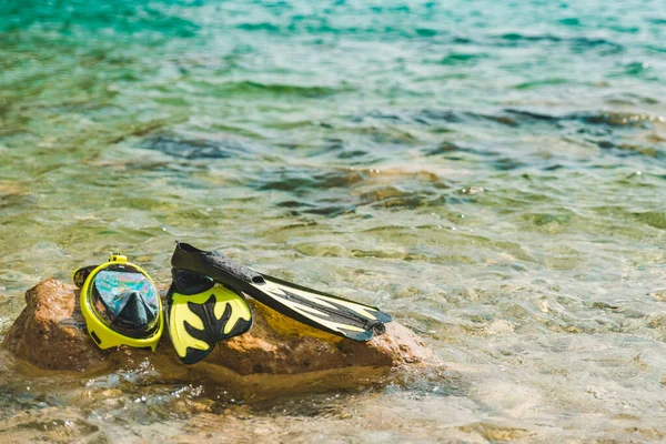 海の水のコピースペースの岩でフリッパー付きシュノーケリングマスク — ストック写真
