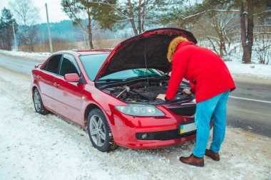 Adam arabanın kaputunu açtı. Karayolunda arıza var. Sigorta yardımı. Boşluğu kopyala