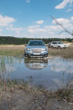 off road konsepti. Araba bataklık bariyerini aşıyor. Boşluğu kopyala