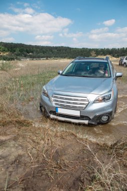 off road konsepti. Araba bataklık bariyerini aşıyor. Boşluğu kopyala