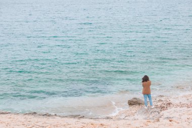 Rüzgarlı deniz sahilinde dikiz aynasından genç bir kadın. Boşluğu kopyala