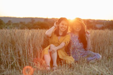 İki genç ve olgun nesil. Anne ve kızı gün batımında tarlada. Boşluğu kopyala