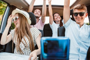 Araç navigasyonunda dört arkadaş telefonda. Yol gezisi