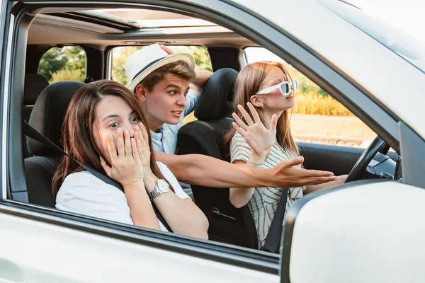 four friends in car navigation on phone. road trip