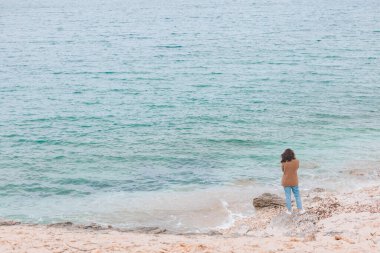 Rüzgarlı deniz sahilinde dikiz aynasından genç bir kadın. Boşluğu kopyala