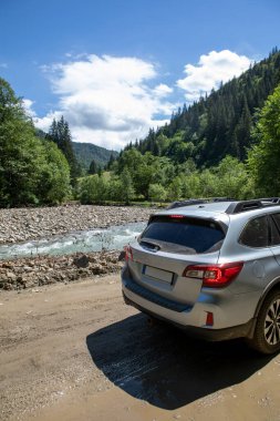 Nehir kenarındaki dağlarda bir arazi aracı. Yolculuk konsepti. off road