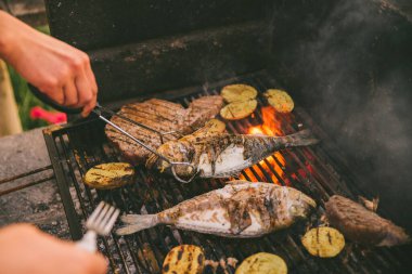 Açık havada ızgarada balık ve patates pişirmek.