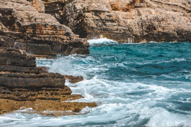 Beyaz köpüklü kayalık deniz dalgalarının manzarası. Boşluğu kopyala