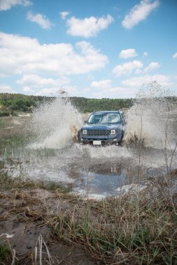 off road konsepti. araba bataklık bariyerini aşıyor