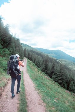 Dağlardaki genç yürüyüşçü. Yaz yürüyüşü yolu. Boşluğu kopyala.