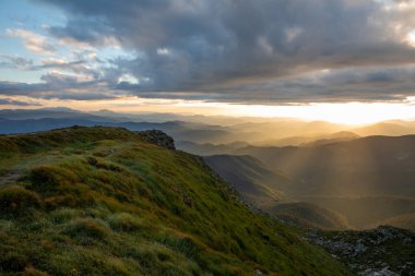 Dağların tepesindeki günbatımının manzarası. Boşluğu kopyala