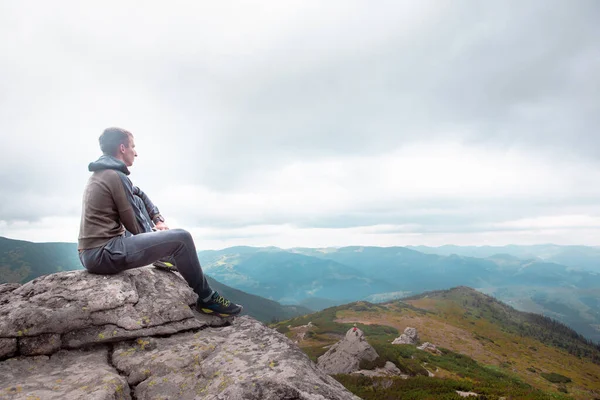 Ung Stærk Mand Sidder Klippen Toppen Bjergene Peak Nyder Udsigten - Stock-foto