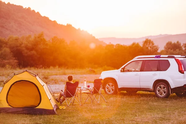 Kvinna Tittar Solnedgången Ovanför Berg Floden Campingkoncept Kopieringsutrymme — Stockfoto