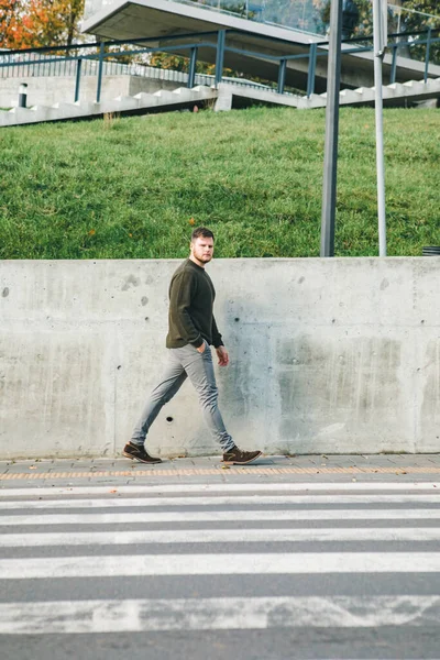 man in sweater walking by sidewalk copy space