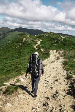 Dağlardaki genç yürüyüşçü. Yaz yürüyüşü yolu. Boşluğu kopyala.