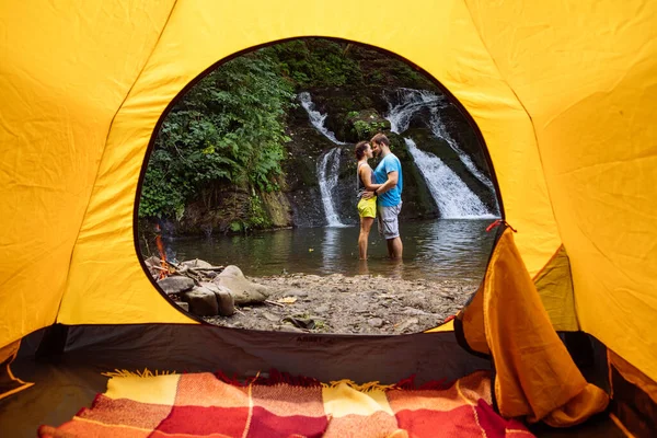 Couple Standing Lake Waterfall Background View Yellow Camping Tent Summer — Φωτογραφία Αρχείου