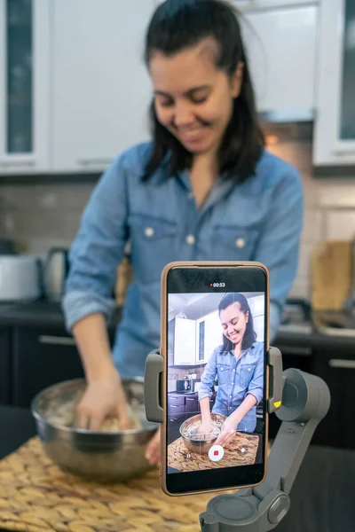 用面粉烘焙做饭的女人在电话里打Vlog — 图库照片