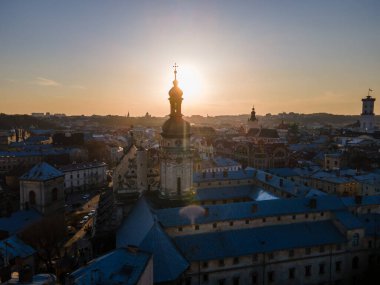 Eski Avrupa şehrinin üzerindeki günbatımının havadan görünüşü. Kilise çan kulesi. Mimari. İHA atışı