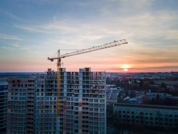 aerial view of apartment construction site with crane city development. sunset above city