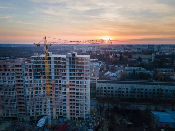 有起重机城市发展的公寓建筑工地的航拍图 日落在城市上空 — 图库照片