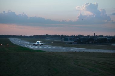 Gün batımında uçak pistte. Boşluğu kopyala