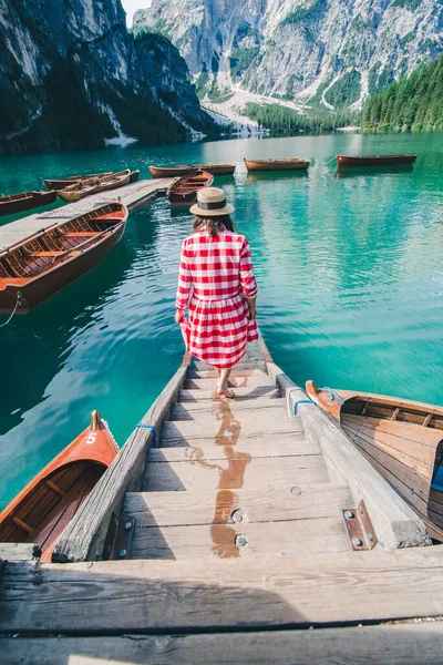 Mladá jemná žena v červených kostkovaných šatech bosá chůze po dřevěných schodech z lodní stanice vede k jezeru — Stock fotografie