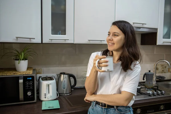 Young woman drinking coffee at the kitchen — Stock Photo, Image