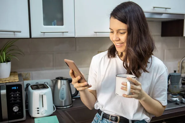 Woman Drinking Morning Coffee Tea Kitchen Surfing Internet Phone Checking — Stock Photo, Image