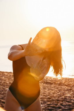 Genç ve güzel bir kadın kumsalda eğleniyor.