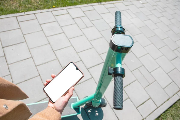 Alquiler de patada eléctrica scooter usando el teléfono — Foto de Stock