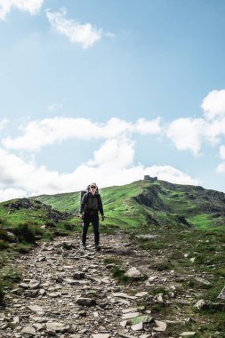 Dağlardaki genç yürüyüşçü. Yaz yürüyüşü yolu. Boşluğu kopyala.