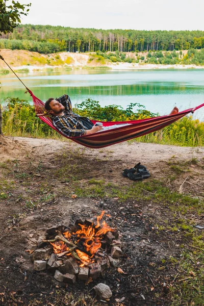 Man Hängmatta Vid Sjön Stranden Nära Lägret Brand Turism Koncept — Stockfoto