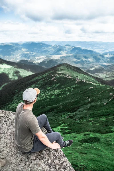 Ung Stærk Mand Sidder Klippen Toppen Bjergene Peak Nyder Udsigten - Stock-foto