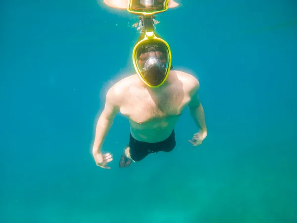 man swimming underwater with snorkeling musk summer sea vacation