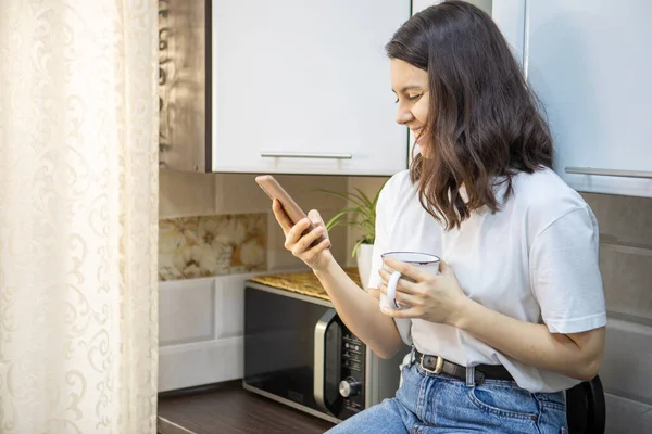 Woman Drinking Morning Coffee Tea Kitchen Surfing Internet Phone Checking — Stock Photo, Image