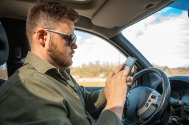 Adam arabada oturuyor. Dikkati dağılmış bir hayat sürüyor.