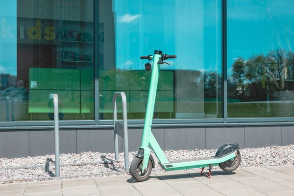 rental electric scooter at city street near office building