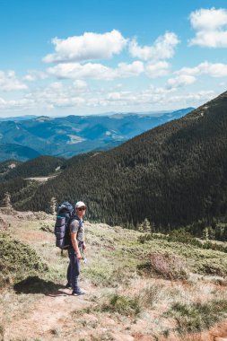 Dağlardaki genç yürüyüşçü. Yaz yürüyüşü yolu. Boşluğu kopyala.