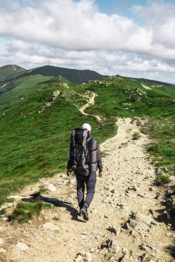 Dağlardaki genç yürüyüşçü. Yaz yürüyüşü yolu. Boşluğu kopyala.