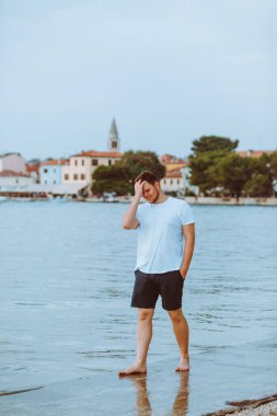 Hırvatistan 'da yaz akşamları deniz kıyısında gezen bir adam. tatil kavramı