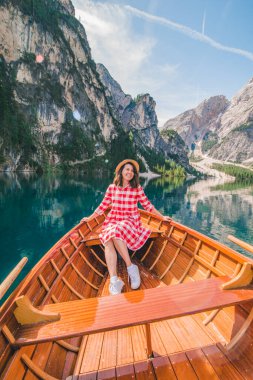 İtalya 'daki lago di braies gölünde büyük kahverengi bir teknede oturan kadın. yaz tatili