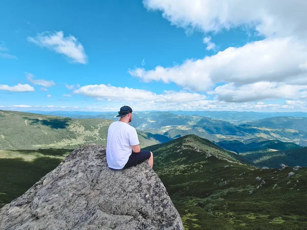 Νεαρός Δυνατός Άντρας Κάθεται Στο Βράχο Στην Κορυφή Των Βουνών — Φωτογραφία Αρχείου